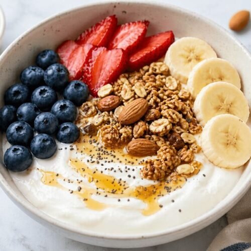 low calorie Greek yogurt bowl with berries, granola, and nuts